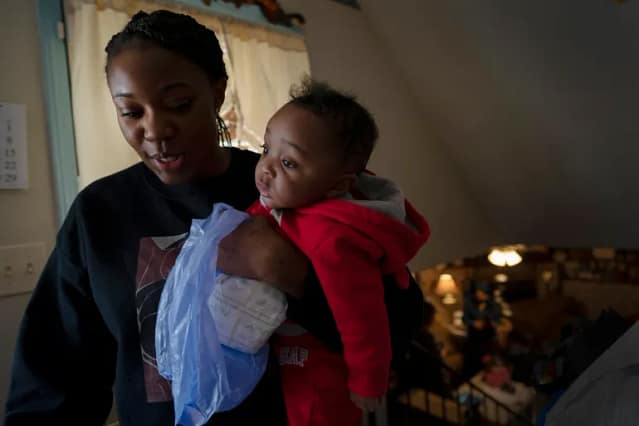 A Black woman holding a Black infant. Photo credits: Wong Maye-E/AP Photo